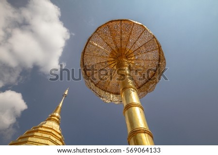 On the way to the sky, spiritual elevation, low angle view of golden buddhist pagoda with gold giant umbrella with cloudy blue sky in the background, Wat Phra That Doi Suthep, Chiang Mai, Thailand 