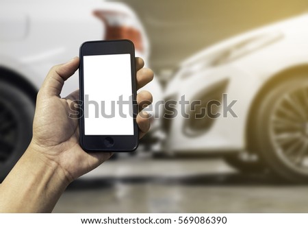 Hand holding smart phone with blank screen on Car crash background