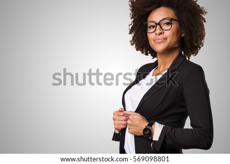 business black woman adjusting her clothes on a grey background Royalty-Free Stock Photo #569098801