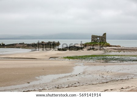Colorful panoramic landscape picture of an old tower ruin on the beach in Ireland in spring in in the middle of the sea.