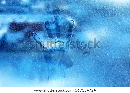 Human hands on frozen glass winter