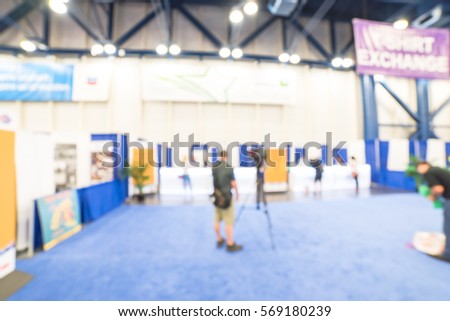 Blurred abstract of cameraman recording/videotaping at the conventional hall of Marathon event expo in Houston, Texas, US.  Blurry professional operator film or video camera on duty, bokeh background.