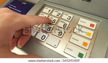 ATM machine and close-up man hand pushing on the pin button. 