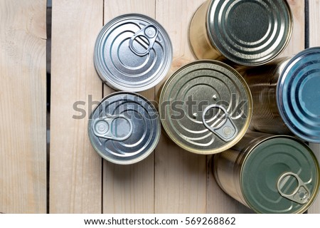 Tin cans for food on wooden background Royalty-Free Stock Photo #569268862