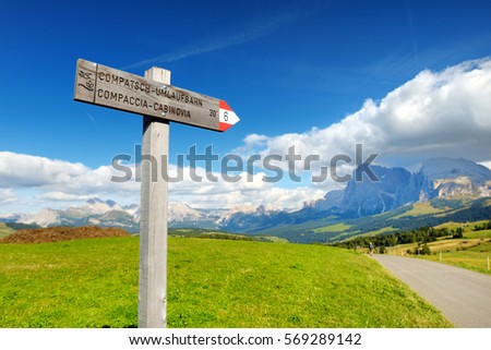Sighnpost in Seiser Alm, the largest high altitude Alpine meadow in Europe, stunning rocky mountains on the background. South Tyrol province of Italy, Dolomites.  