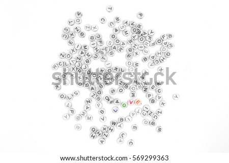 the top view of colorful love message written in small plastic block with black and white alphabet isolated on white background for Valentine's day