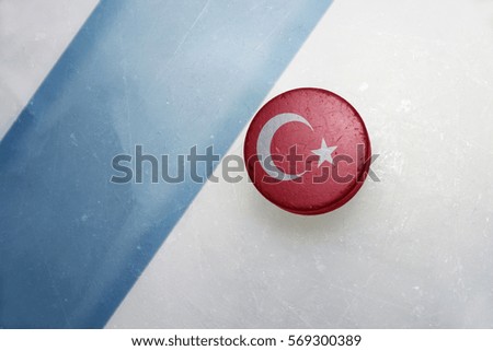 vintage old hockey puck with the national flag of turkey lies near the blue line