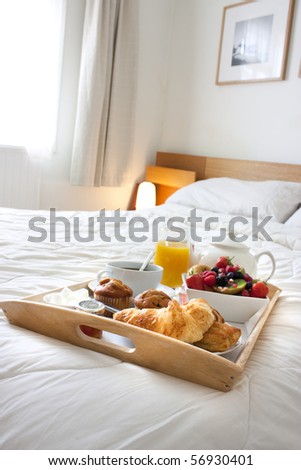 breakfast tray set up on a bed with healthy foods and drink