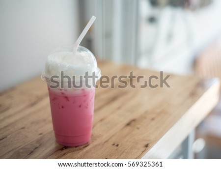Pink milk on Wodden table.