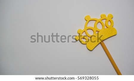 Photo booth props a yellow crown on a white background flat lay. Birthday parties and weddings.