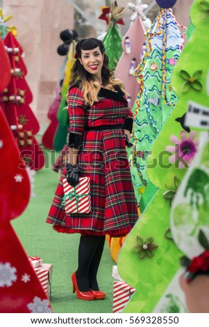 View of a colorful and cute christmas pinup girl with presents.