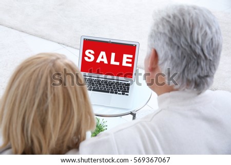 Sale concept. Senior couple using laptop for internet online shopping at home