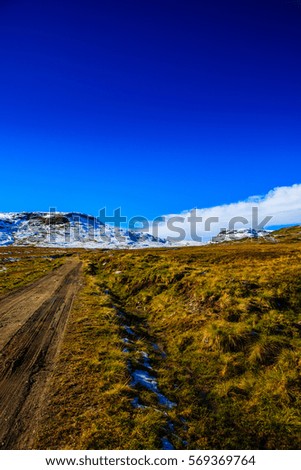 The picture shows the parts of a dirt road that goes over a mountain pass in Norway. It is best accessible by tractor or car with four-wheel drive