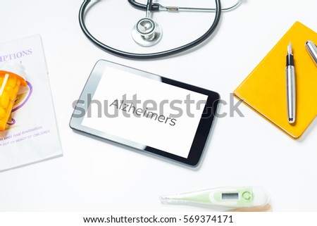 Close Up Photo Of Doctors Tablet On Desk With Alzheimers Typed On Screen With Prescription.