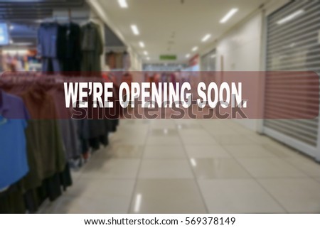 We're opening soon text on blur shopping complex background.