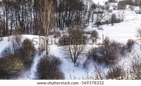 Typical winter landscape of Central Russia. Snowy hills, trees and bushes covered with snow, view from above.