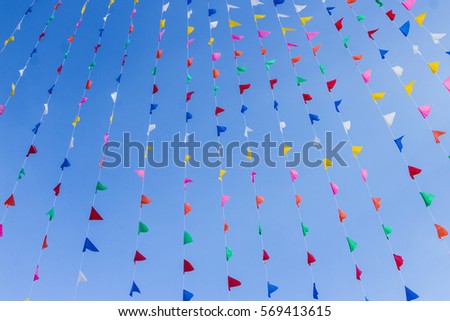 colorful bunting flags against a blue saturated sky background