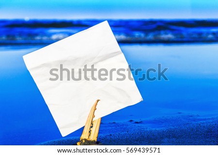White torn piece of paper in crab claw on  blue sea background, text place 