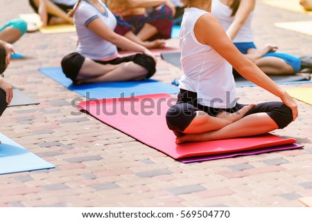 Group free exercise class for people of different age and gender in the city park. International Day of Yoga, summer Royalty-Free Stock Photo #569504770