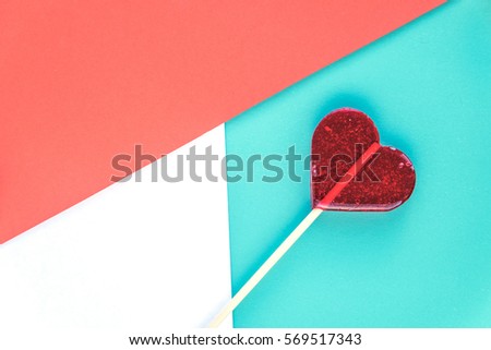 Valentines day background. Red lollipop on a red and blue paper. Mock-up. Shallow Selective focus. Copyspace. Top view