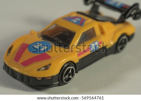 Old yellow car toy on white background with number 21