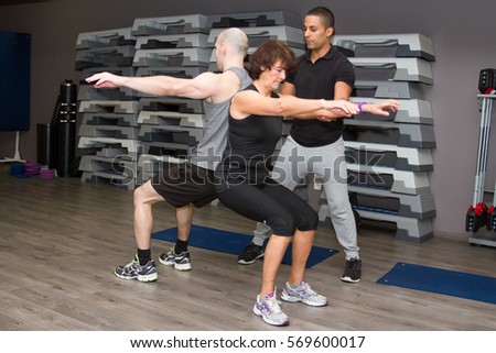 two people doing yoga balance and fitness exercises with coach