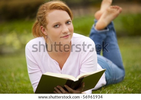 Young woman sitting outside reading