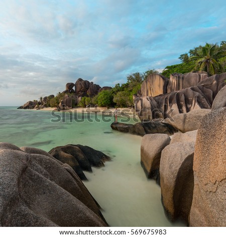Beautifully shaped granite boulders and a dramatic sunset at picture perfect tropical Anse Source d'Argent beach, La Digue island, Seychelles.