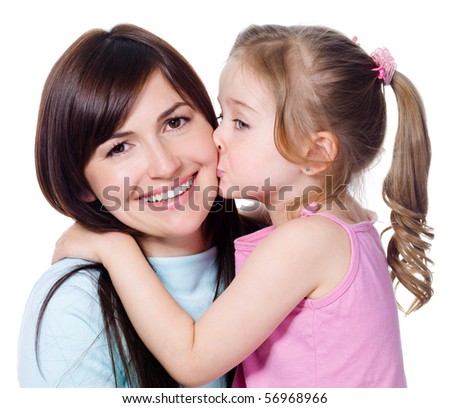 Portrait of little daughter kissing her beautiful happy mother - isolated on white