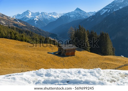 Mountain landscape. Beautiful winter landscape. The slopes of the Alps with the yellow grass. The tops of the highest mountains in the distance.