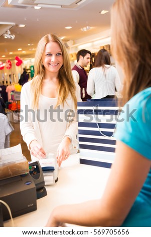 Customers Talking To Sales Person In Fashion Store