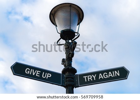 Street lighting pole with two opposite directional arrows over blue cloudy background. Give Up versus Try Again concept.