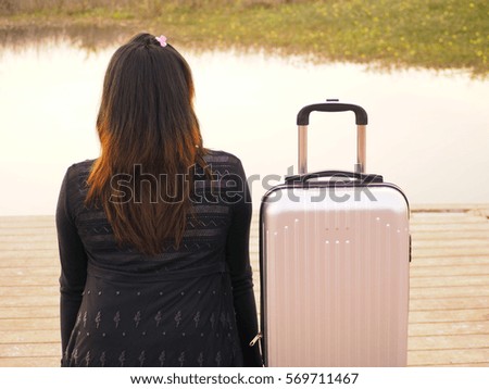 Young girl with traveling bag scenic lake on wooden bridge background, travel concept