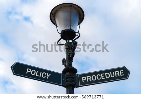Street lighting pole with two opposite directional arrows over blue cloudy background. Policy versus Procedure concept.