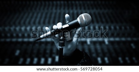 singer hands holding microphone on studio mixer background. hands sign mean love,  concept = love to sing