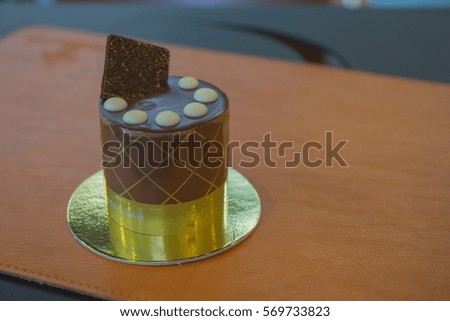 Chocolate cake crispy with white chocolate on top on wooden chopping block / Chocolate cake