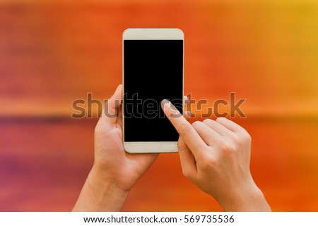Two hands holding mockup smartphone black screen on table