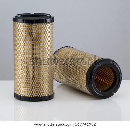 two automotive filter cylindrical shape  on a white background with reflection