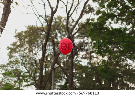 red balloon with smile symbol