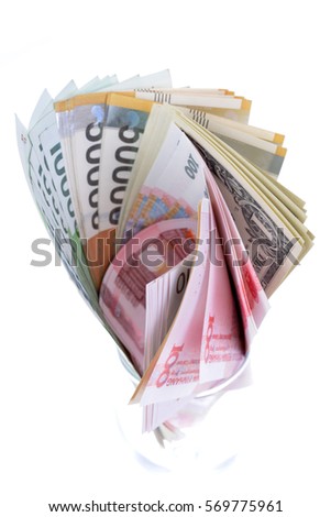 Currency standing in a cup on white background
