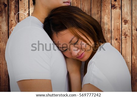 Close-up of couple embracing against wooden planks