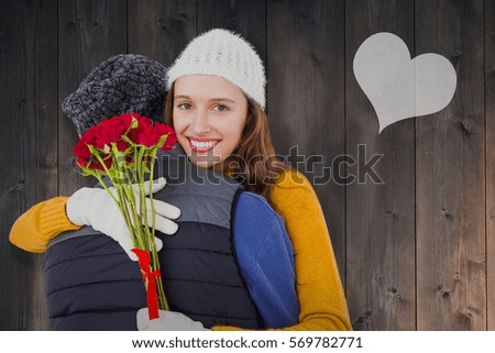 Couple hugging each other with red roses against wooden planks