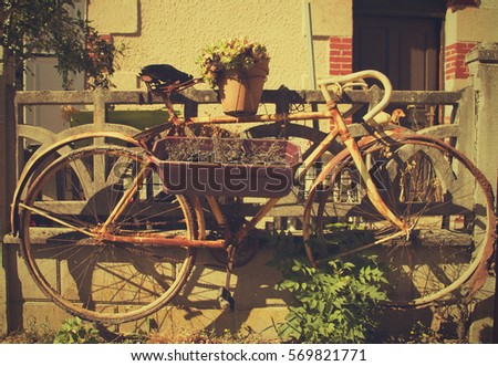 Retro bike flowerpot. Real French village. Real Vintage flowers and bicycle in Europe