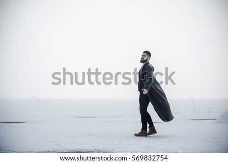 young man in a leather coat dancing on a frozen lake