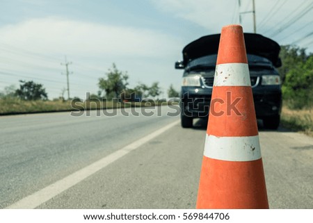 Orange rubber traffic cone on country road. It is used for warning to broken down car on country road, 