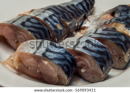 good cold fish appetizer. sliced a tasty marinated mackerel on a plate. closeup