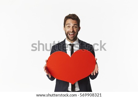 Excited valentine holding red heart in studio