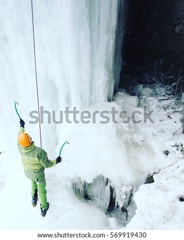 Ice climbing the North Caucasus, man climbing frozen waterfall.