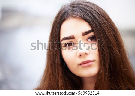 Young girl looking at the camera. Long dark hair and brown eyes . Lifestyle