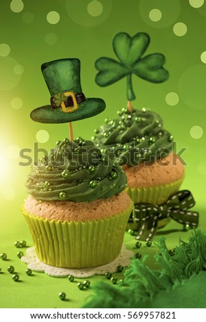Cupcake with clover cakepick on a wooden background